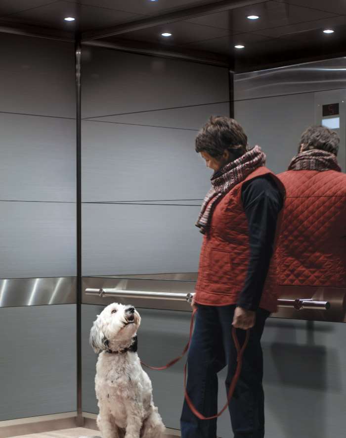 women with dog in elevator cab